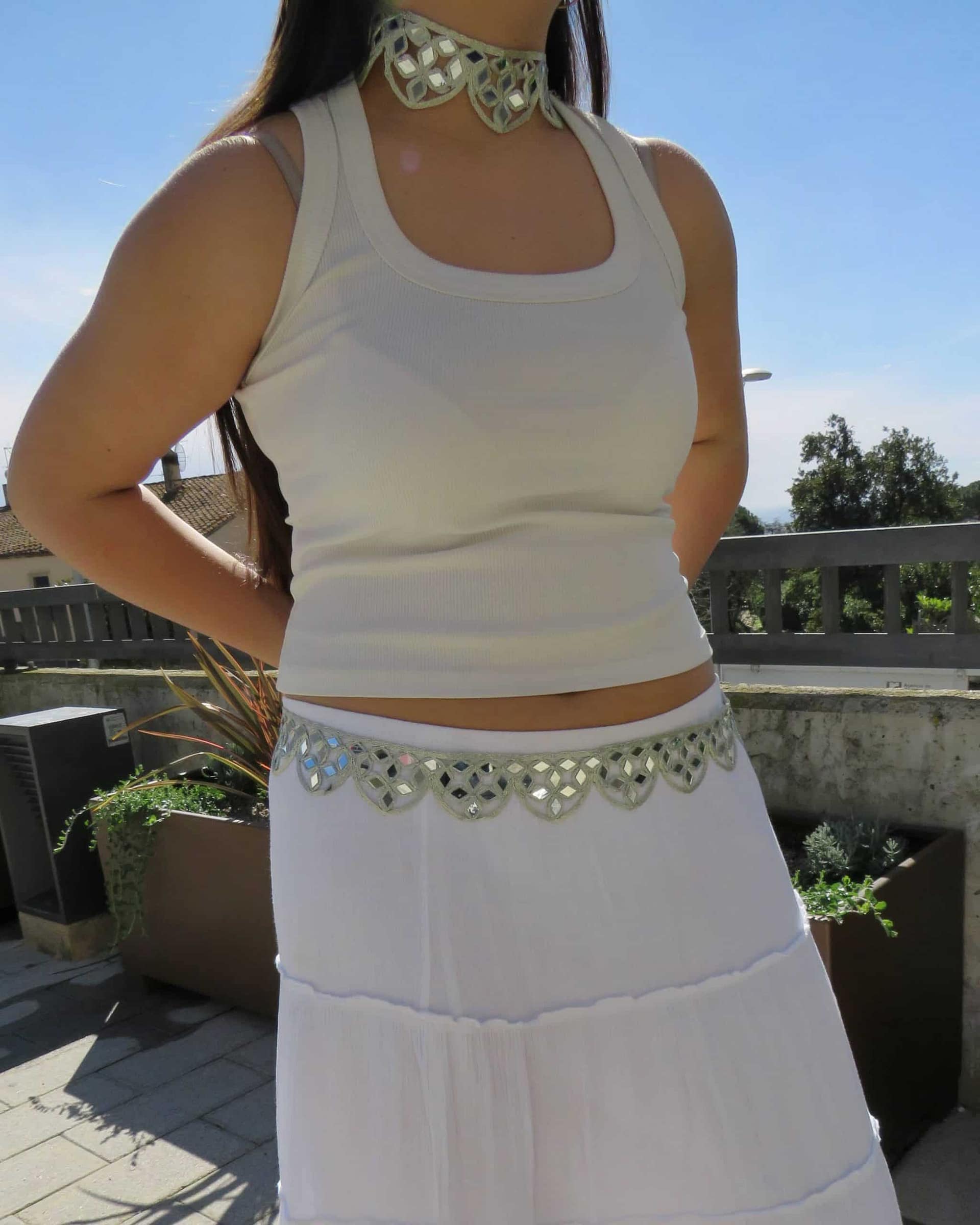 Vestido blanco con accesorios de moda en exterior, ideal para eventos y verano.