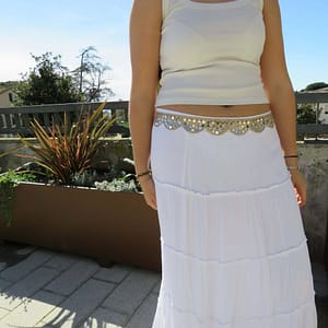 Vestido largo blanco con detalles dorados y accesorios para mujer.